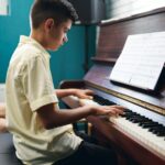 Boy plaing the piano at music lesson