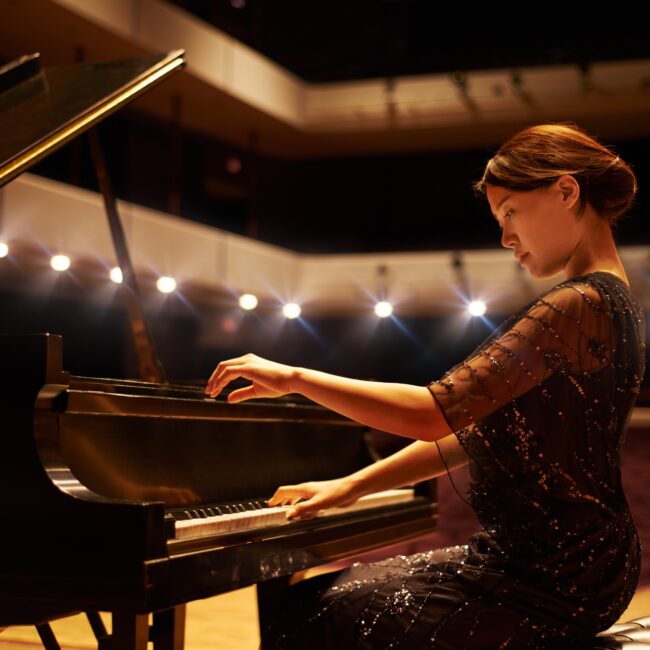 Hitting the right notes. Shot of a young woman playing the piano during a musical concert.