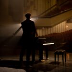 Young,Aspiring,Musician,Standing,Near,Grand,Piano,On,A,Stage